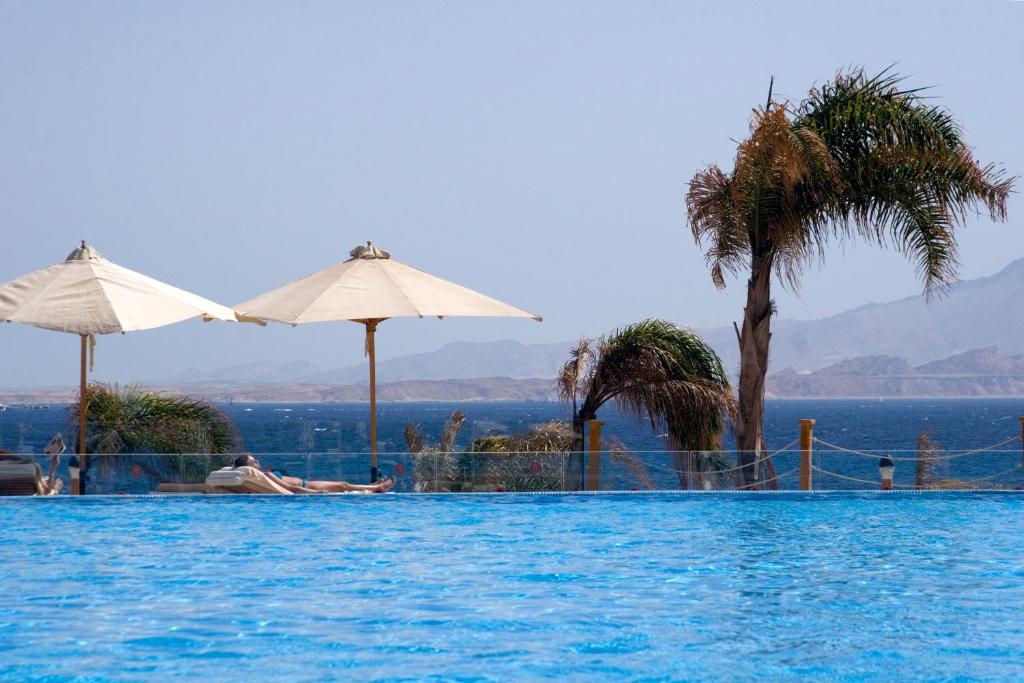 Viesnīcas Cleopatra Luxury Resort baseins ar skatu uz jūru un palmu kokiem