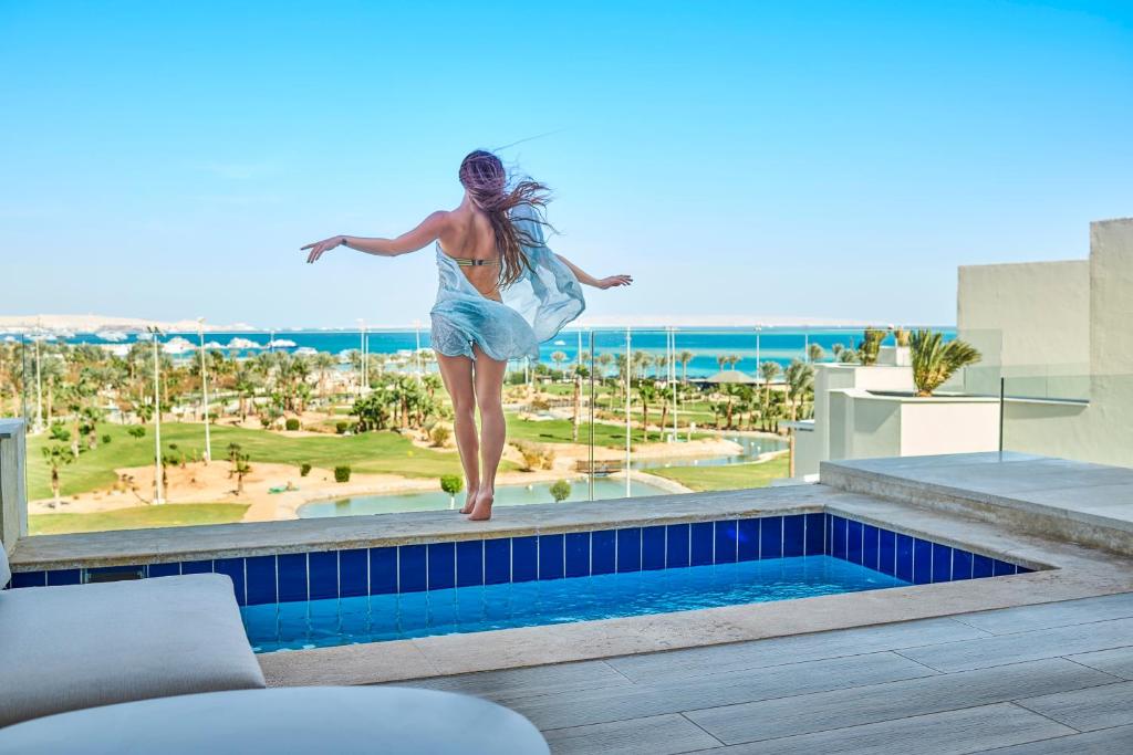 Sieviete pie baseina ar skatu uz jūru Steigenberger Pure Lifestyle.