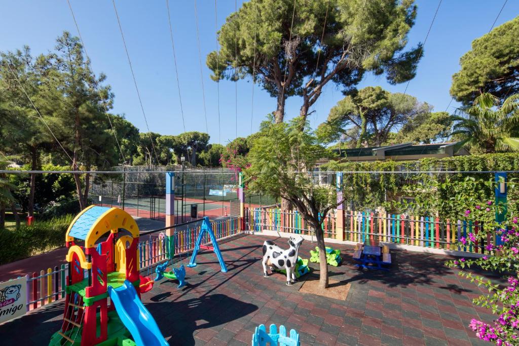 Bērnu laukums pie viesnīcas Pine Beach Belek ar rotaļām un zaļu vidi.