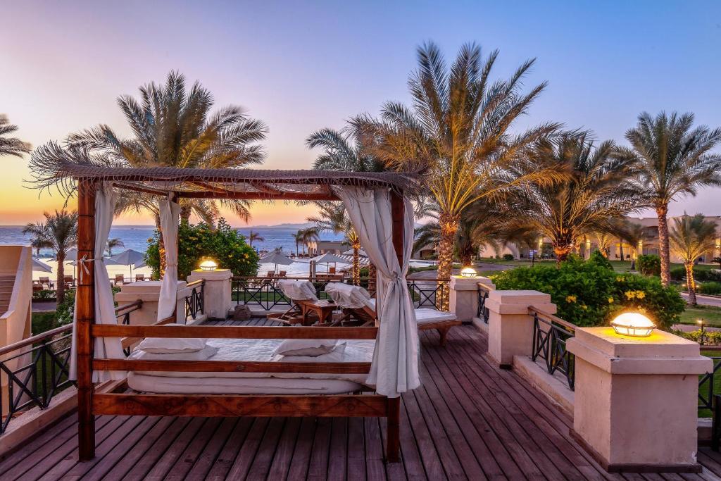 Cleopatra Luxury Resort at sunset with palm trees and lounge area.