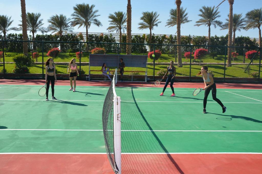 Tennisa spēle pie SUNRISE Royal Makadi Resort ar palmām fona.