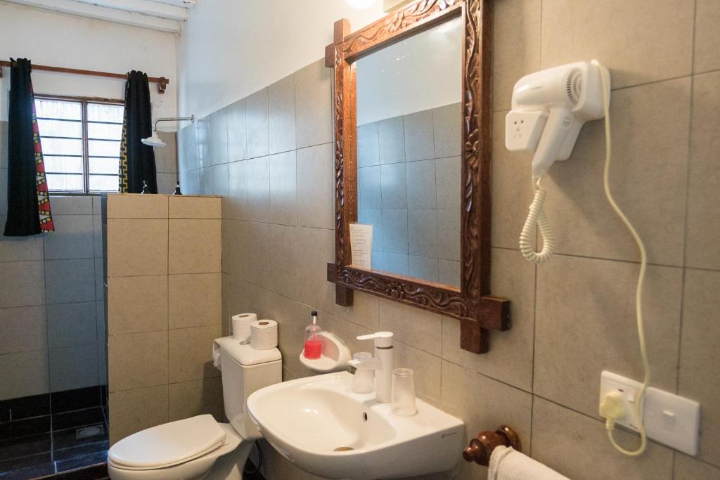 Paradise Beach Resort vannas istaba ar spoguli un fēnu.