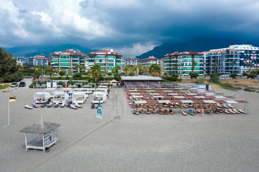 Michell Hotel & Spa pludmale ar sauļošanās krēsliem un kabīnēm piekrastē.