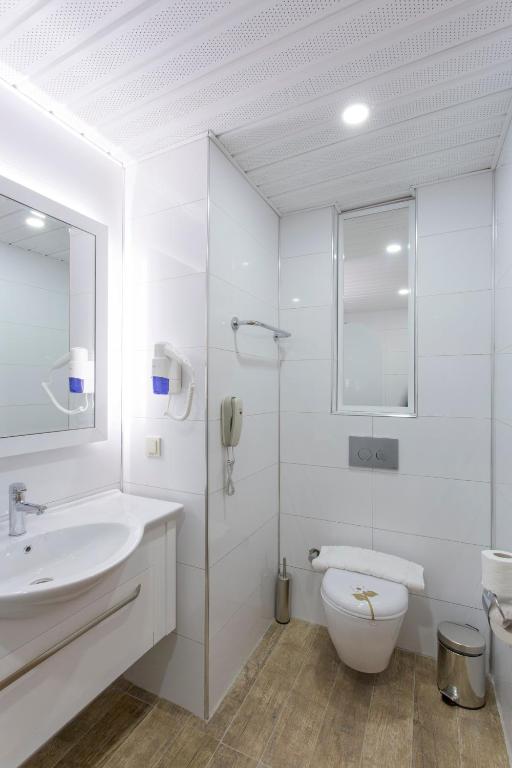 Moderns vannas istaba Michell Hotel & Spa ar spoguli un higiēnas piederumiem.