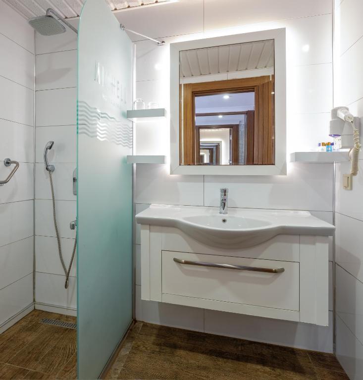 Michell Hotel & Spa moderns vannas istaba ar stikla dušu un spoguli.