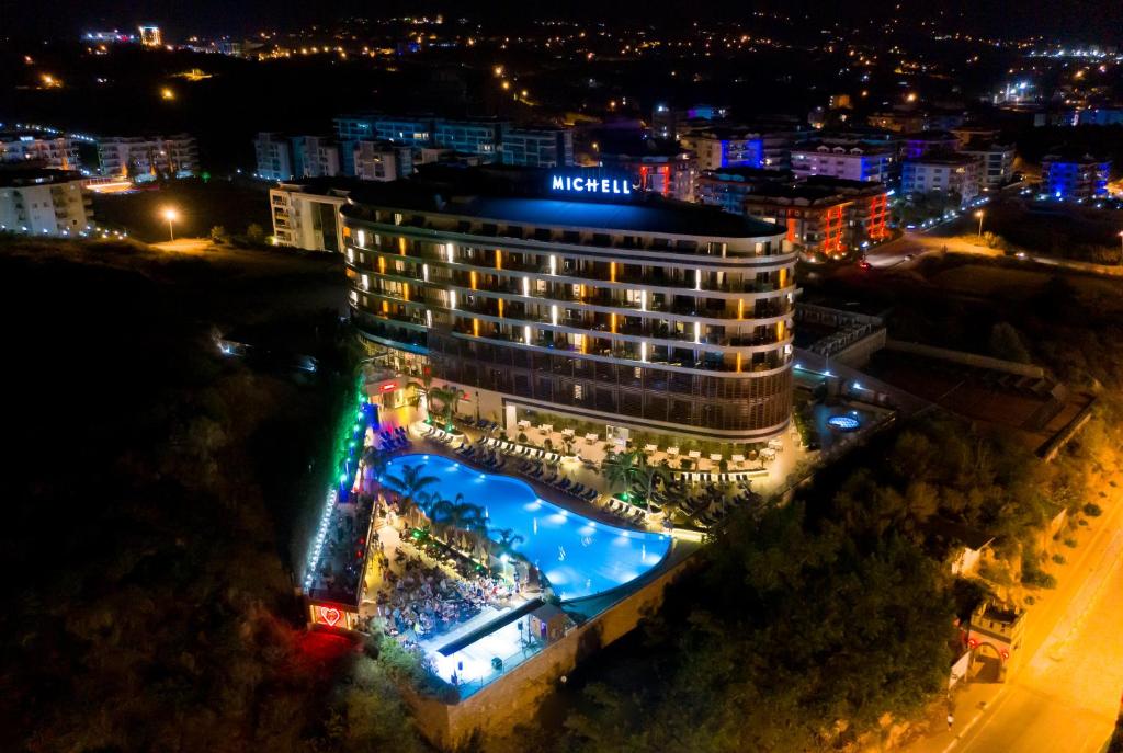 Naktsskatījums uz Michell Hotel & Spa ar apgaismotu baseinu un apkārtni.