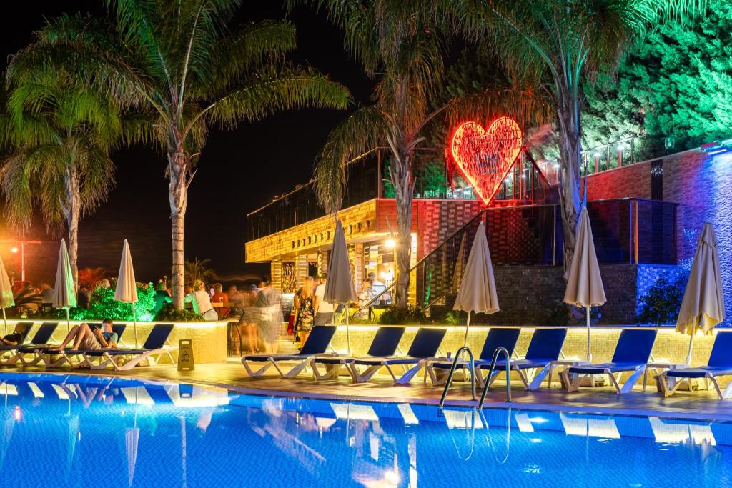 Michell Hotel & Spa baseins ar gaismas dekorācijām naktī.