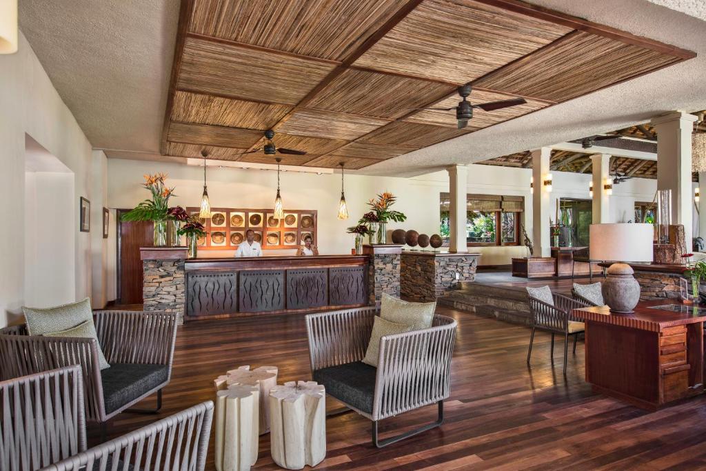 Viesnīcas Heritage Awali elegants reģistratūras dizains ar dabīgām materiālu detaļām.