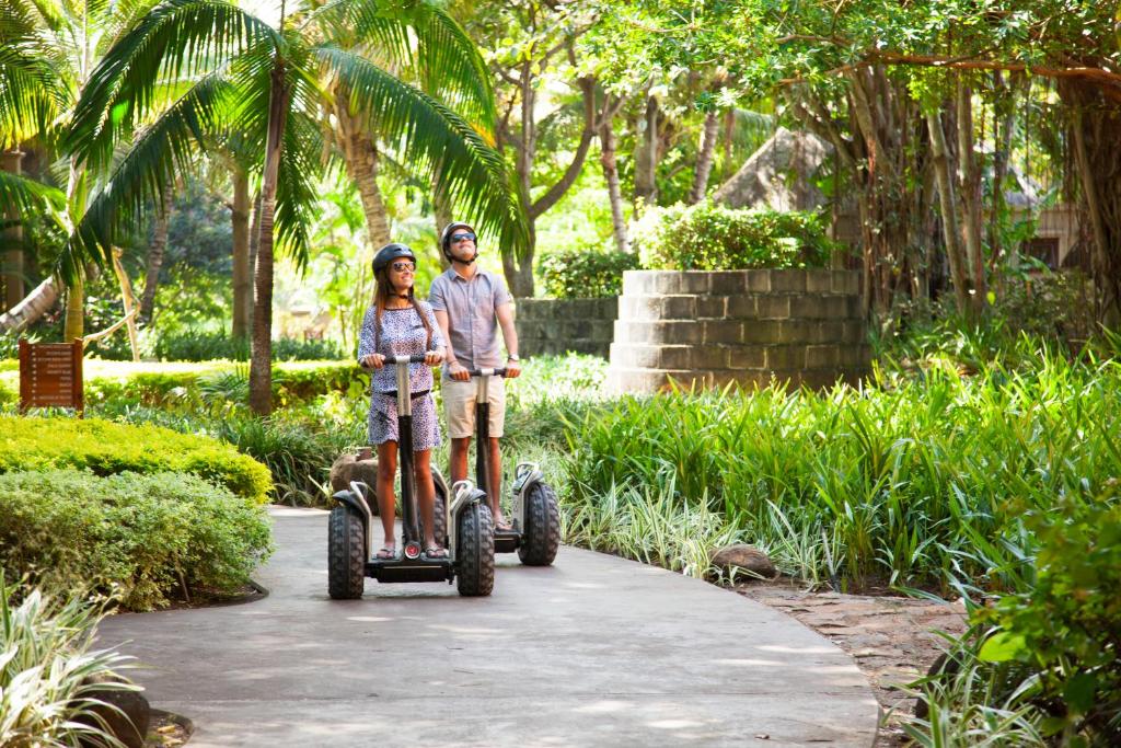 Pāris izklaidējas ar segveikiem, izpētot Heritage Awali dārzu.