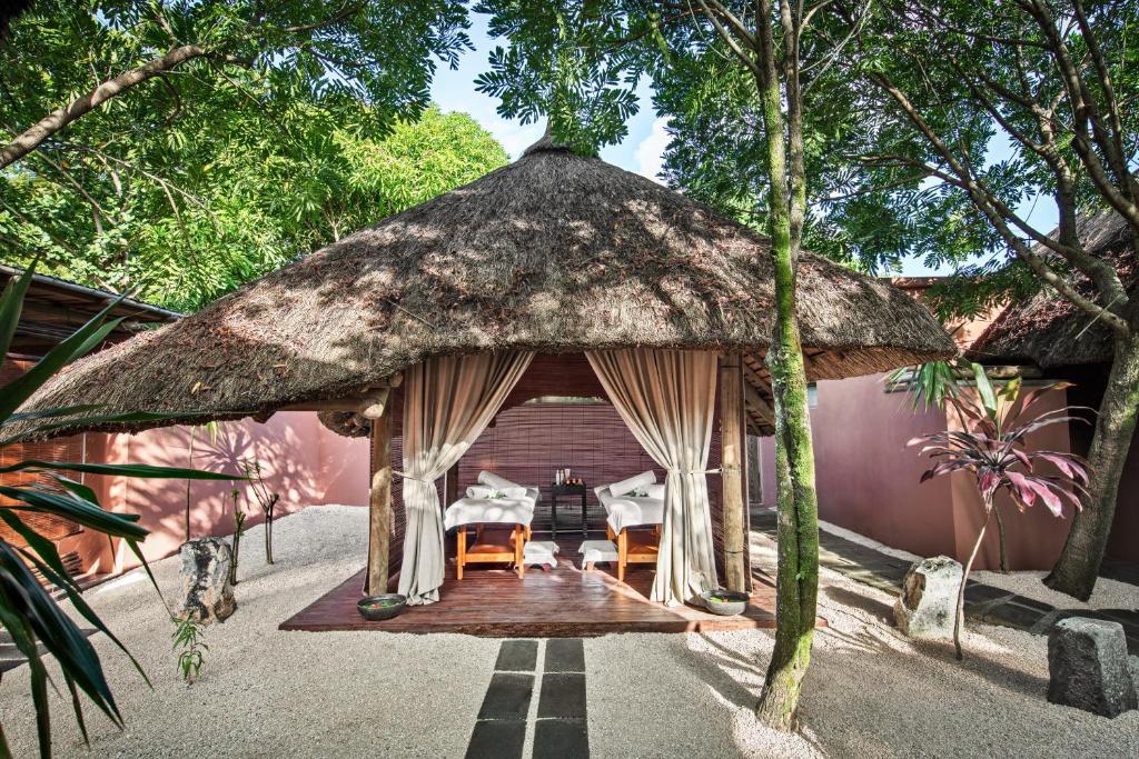 Relaksējoša masāžas kabīne pie viesnīcas Heritage Awali, ieskauta zaļumā.