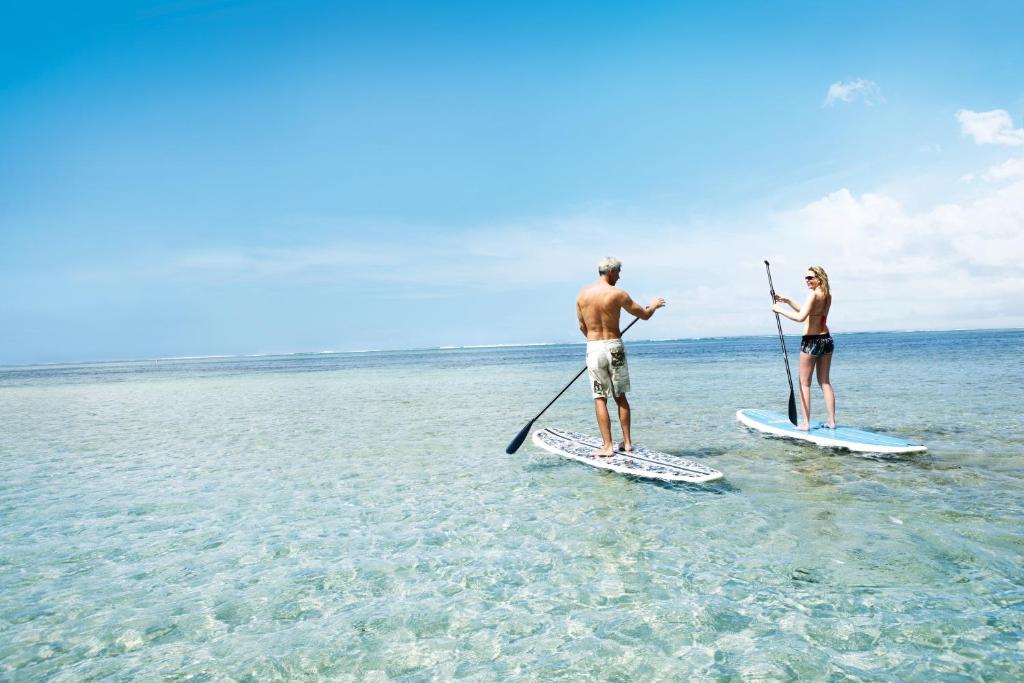 Pāris, kas nodarbojas ar stāvošo airēšanu piekrastē, Heritage Awali.