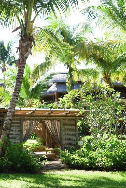 Viesnīcas Heritage Awali relaksējoša kūrorta zona ar palmām un atpūtas telti.