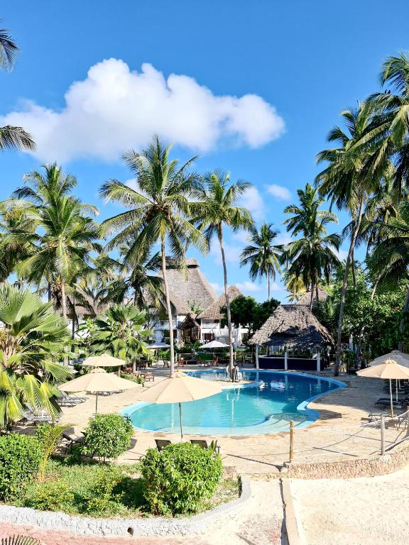 Paradise Beach Resort baseins un palmas saulainā dienā