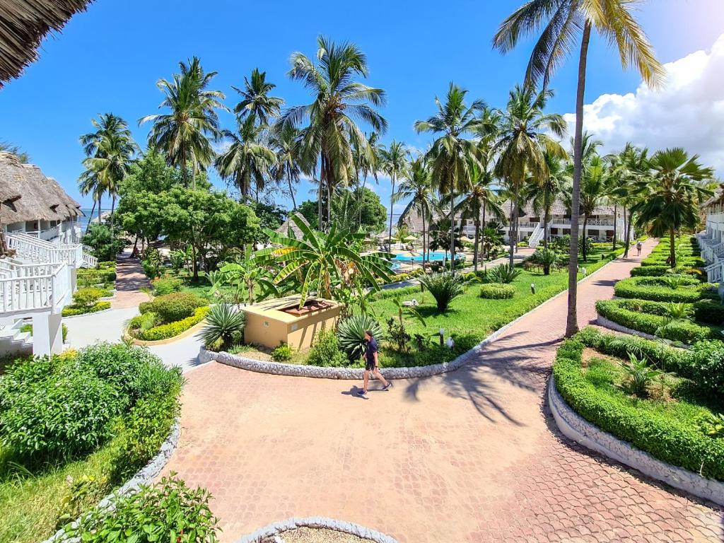 Paradise Beach Resort tropiska ainava ar palmu kokiem un dārziem.