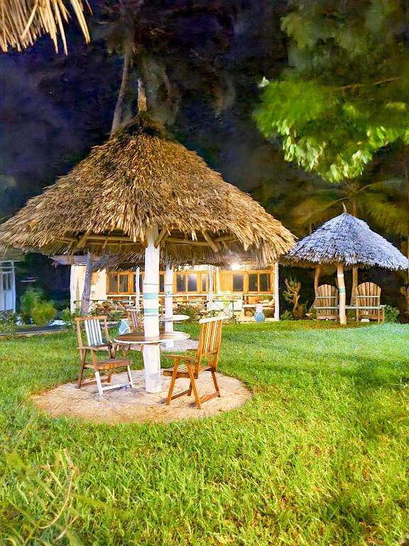 Tropiska zona ar sauļošanās krēsliem pie Paradise Beach Resort nakts laikā