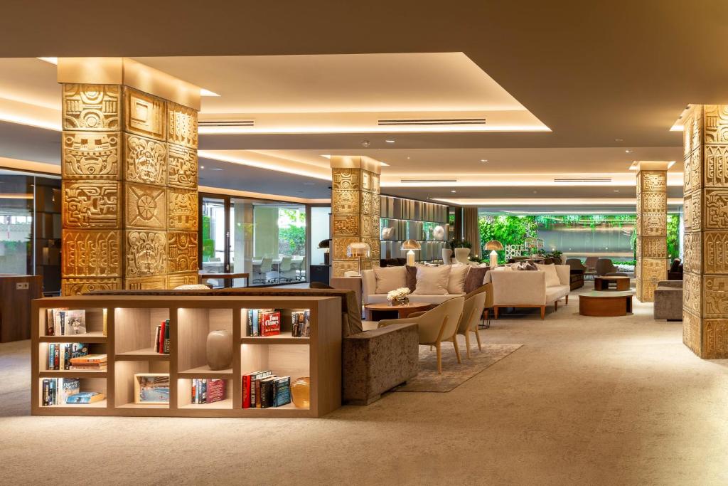 Moderns viesnīcas interjers ar greznu apgaismojumu, dekoratīvām kolonām un grāmatplauktu, piedāvā relaksējošu atmosfēru. Eleganti mēbeļu komplekti un zaļie augi papildina telpas estētiku.