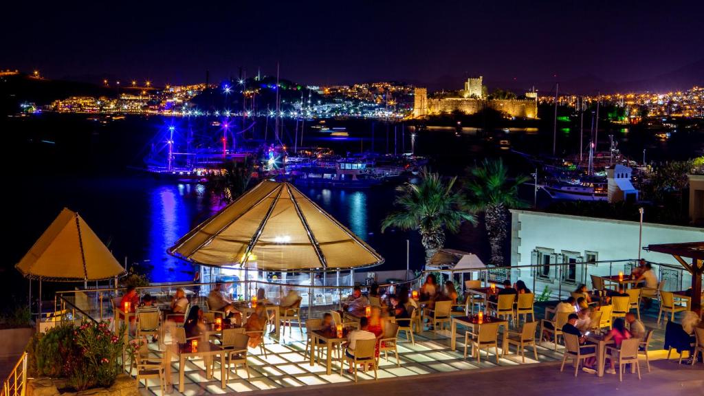 Vakara skats uz Diamond of Bodrum Hotel terasi ar gaismas spēlēm piekrastē.