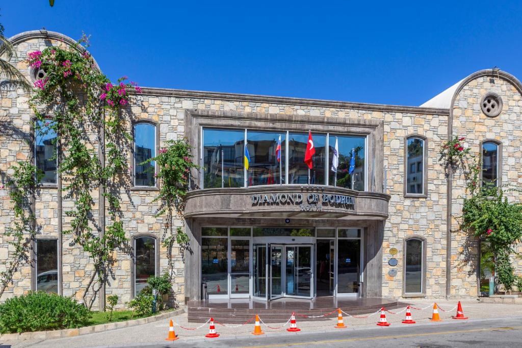 Ieeja uz Diamond of Bodrum viesnīcu, apkārt ziedošas augu kāpnes.