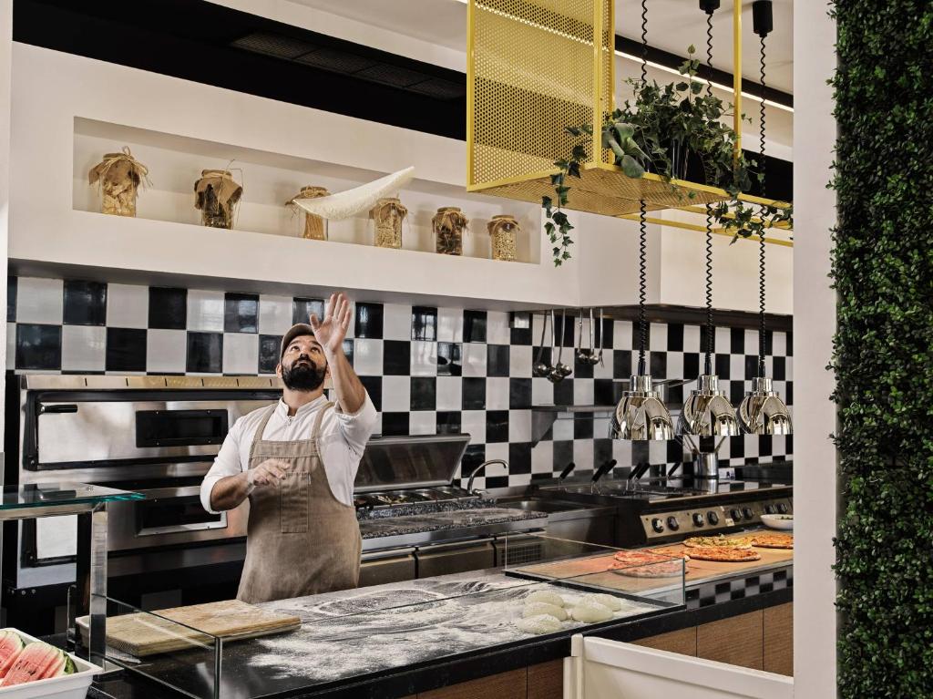 Šefpavārs gatavo ēdienus viesnīcā Esperides Beach modernā virtuvē.