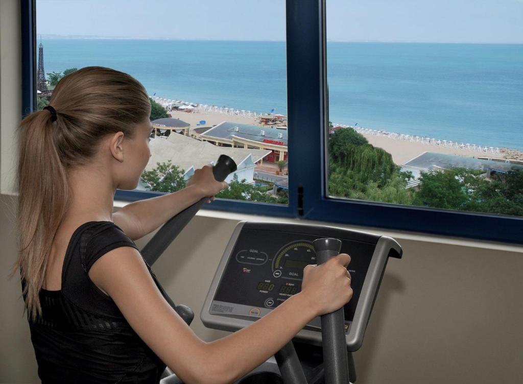 Trenējoša persona izmanto trenažieri ar skatu uz pludmali un jūru. Vides apstākļi veicina relaksāciju un motivāciju sportot.