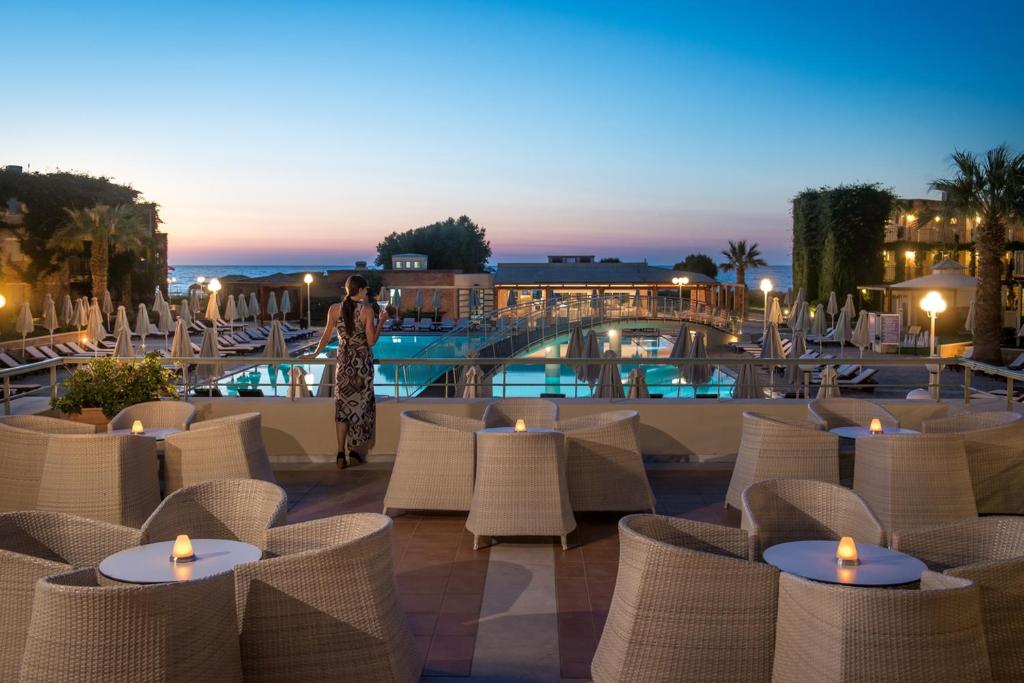 Bella Beach Hotel terase ar skatu uz baseinu un jūru saulrietā
