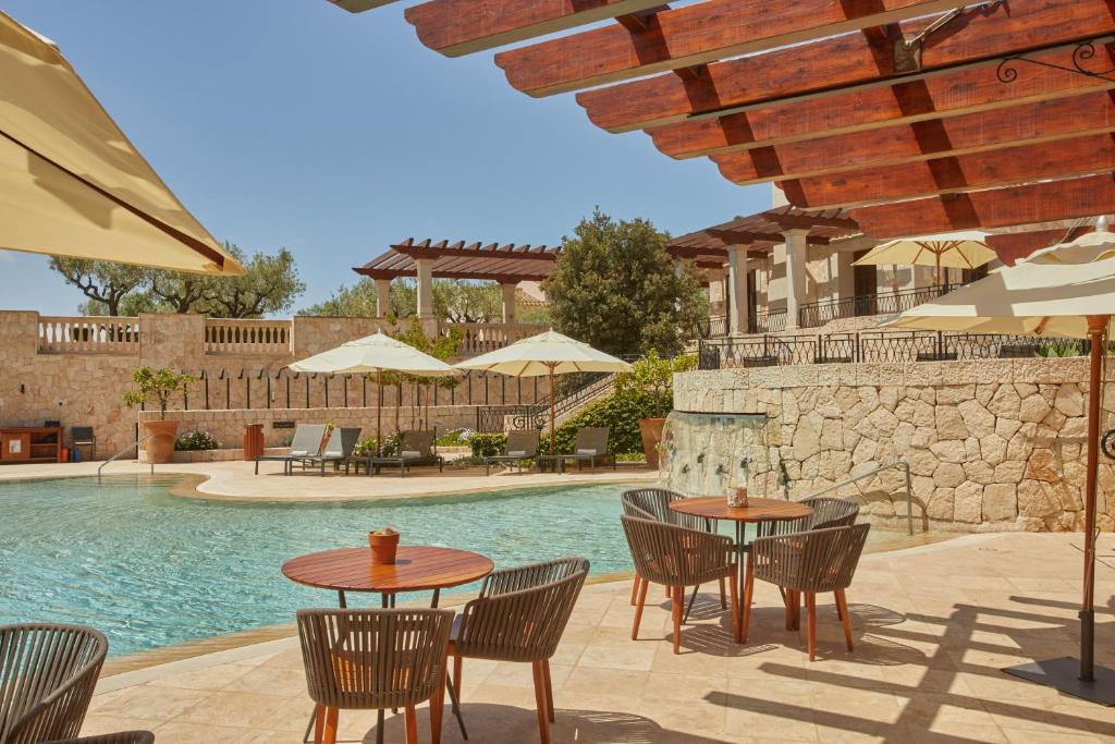 Atpūtas vieta pie baseina ar saulessargiem un ērtām mēbelēm, apzaļumota teritorija un akmens sienas. Ideāla vieta relaksācijai un atpūtai.