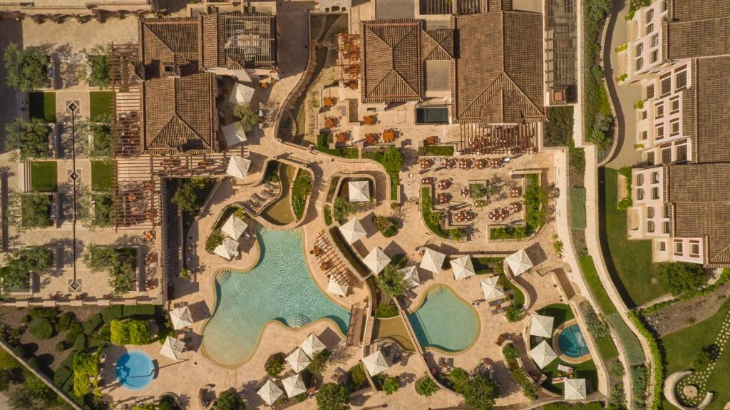 Greznas viesnīcas komplekss ar baseiniem un atpūtas zonām, redzams no putna lidojuma. Vides arhitektūra apvieno dārza elementus un mūsdienīgu dizainu.