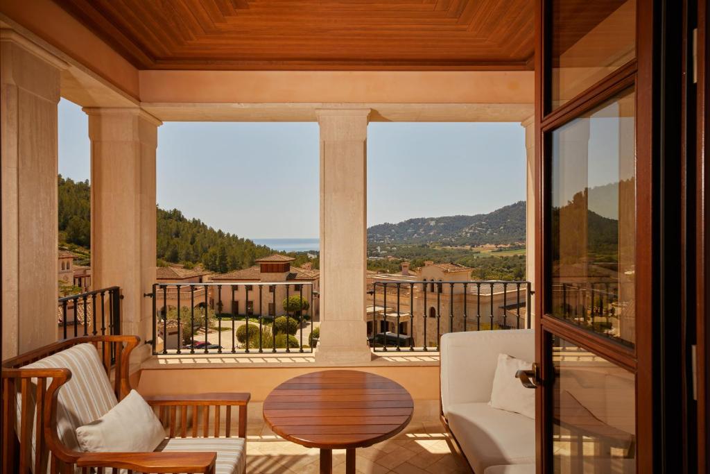 Balkons ar skatu uz jūru un apkārtējo ainavu, kurā redzamas modernas mēbeles un plašas terases. Ideāla vieta relaksācijai un baudīšanai.