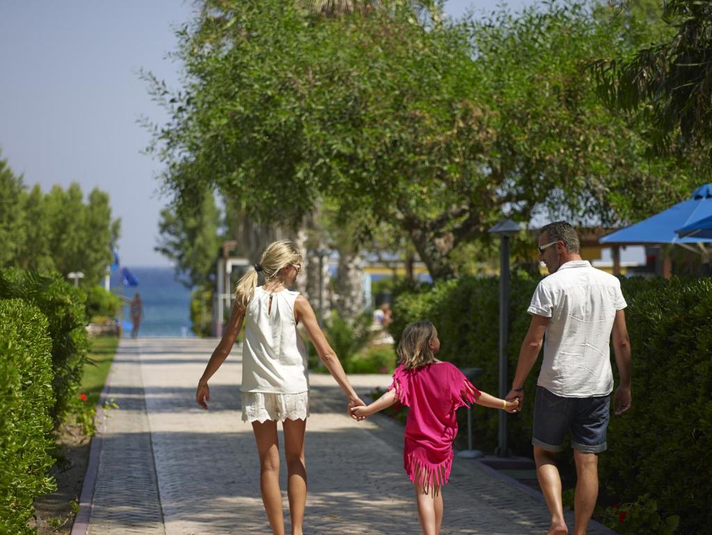 Ģimene pastaigā pa ceļu pie Esperides Beach, piekrastē.