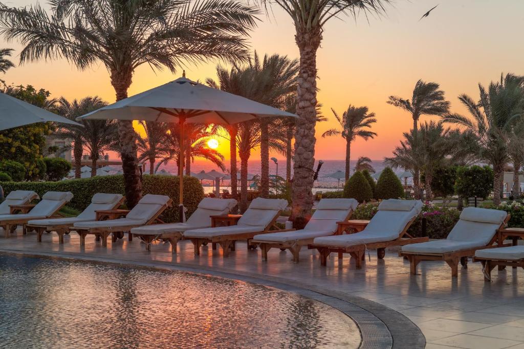 Saulriets pie Cleopatra Luxury Resort pie baseina ar palmām.