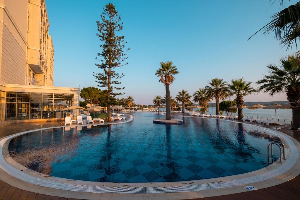 Lielisks skats uz baseinu pie viesnīcas Duja Didim, apkārt palmām.
