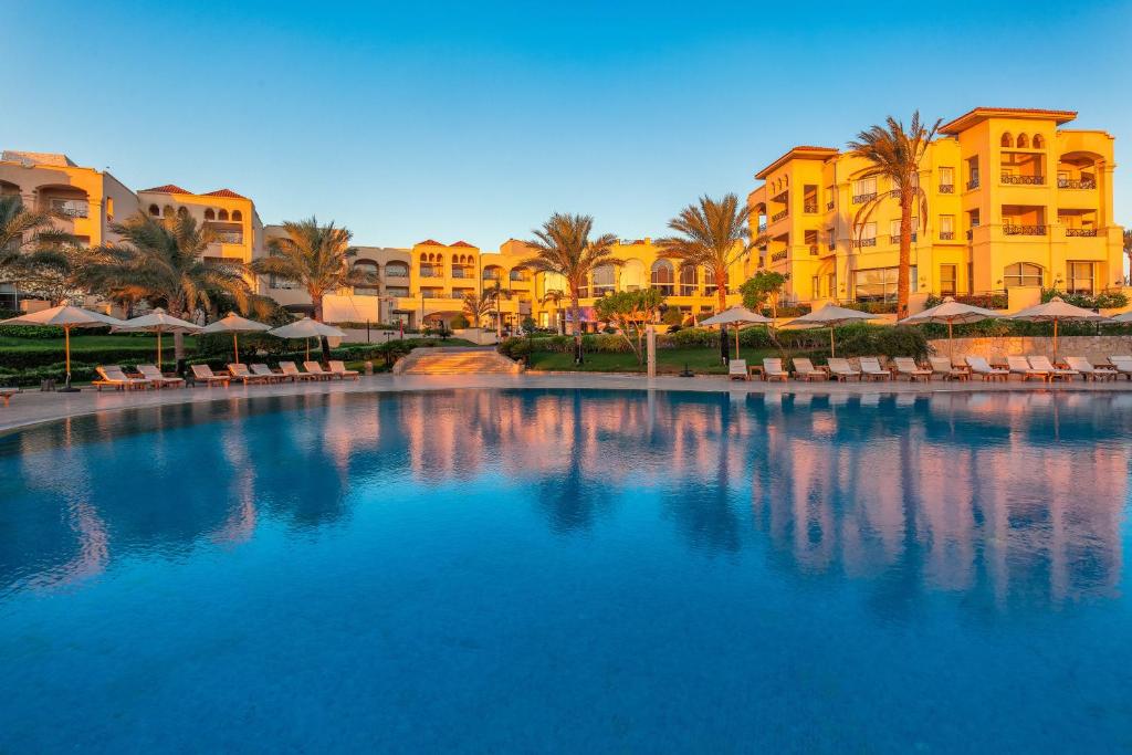 Cleopatra Luxury Resort piekrastes baseins ar palmām un viesnīcas ēkām