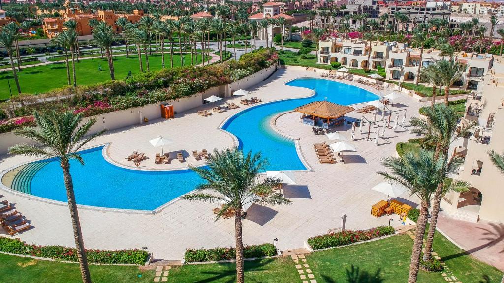Cleopatra Luxury Resort baseins ar saulessargiem un palmām piekrastē