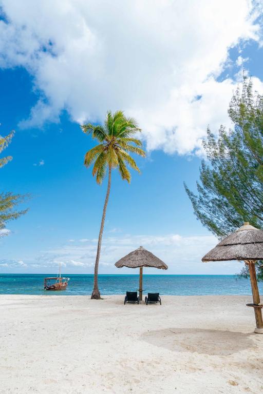 Idilliska pludmale The Residence Zanzibar kūrortā ar zilām debesīm.