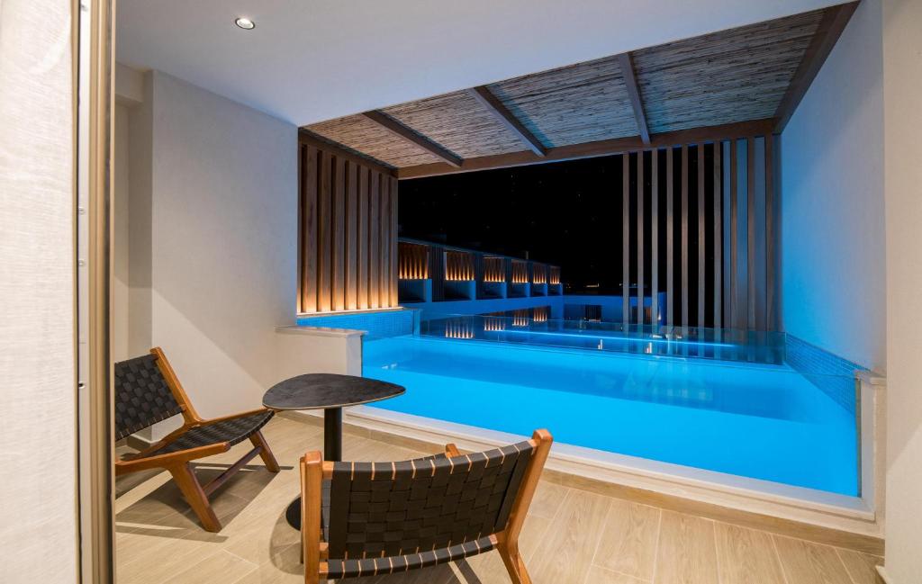 Akasha Beach Hotel & Spa numura balkons ar skatu uz baseinu naktī