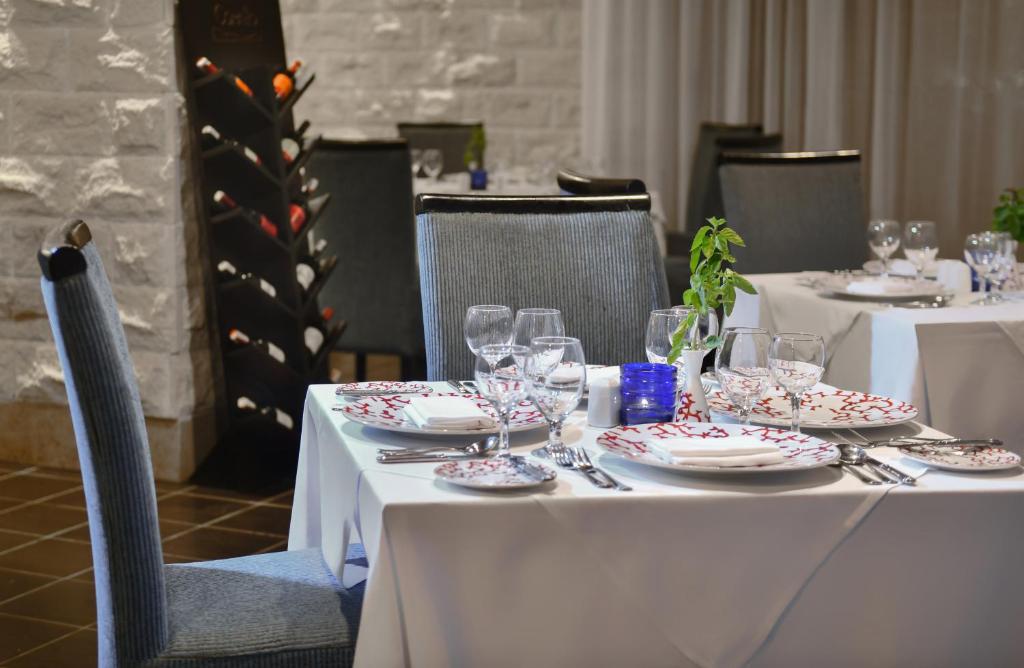 Elegant dining setup at Jaz Aquamarine Resort with decorated plates and wine rack.