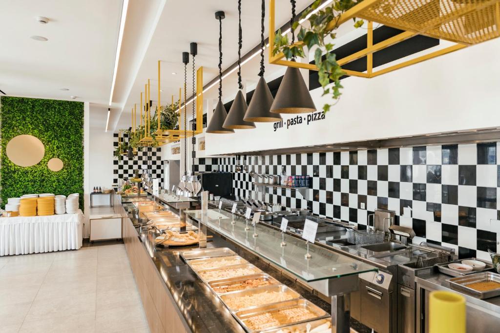 Moderns bufetes stils restorāns pie Esperides Beach ar zaļām akcentu sienām.