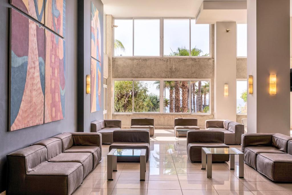 Mūsdienīgs viesnīcas gaiteņi ar mākslas darbiem un komfortablām mēbelēm pie Esperides Beach.