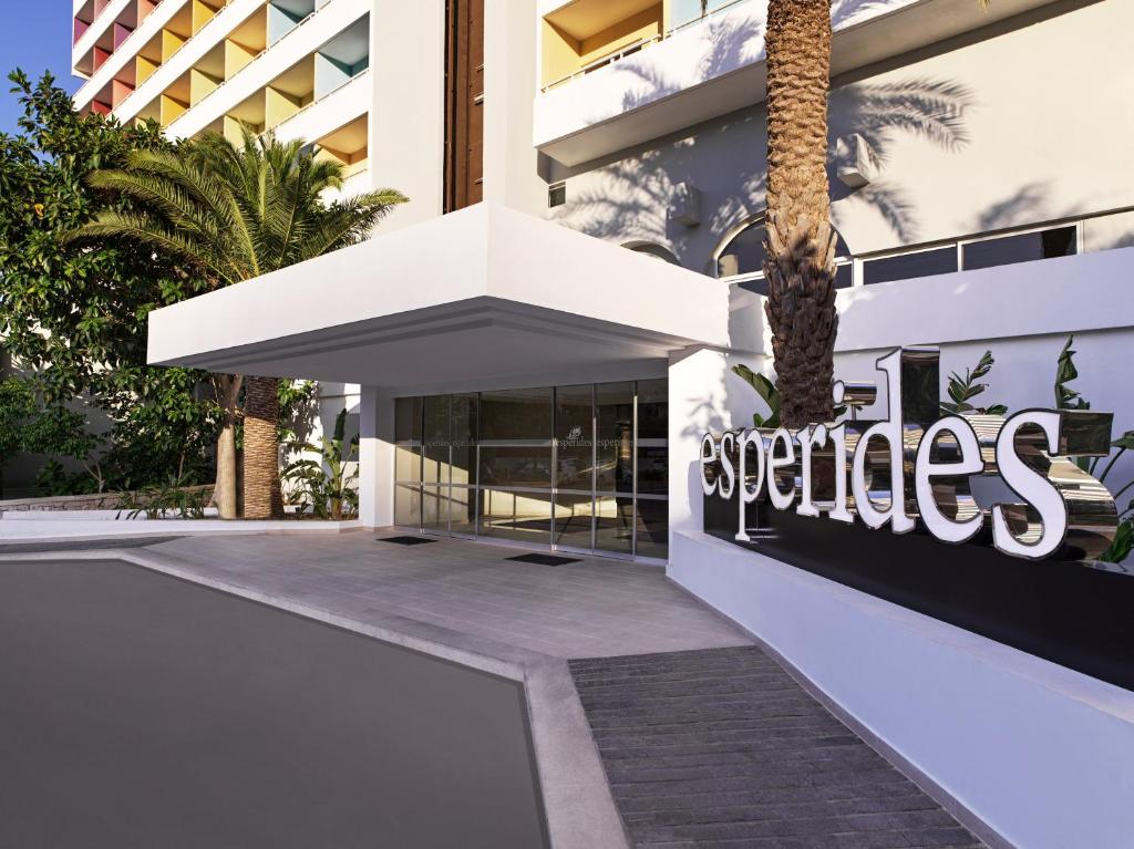 Viesnīcas Esperides Beach ieeja ar modernu dizainu un zaļumiem apkārt.