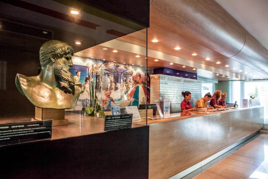 Reģistratūra viesnīcā Esperides Beach ar skulptūru un viesmīlīgu personālu