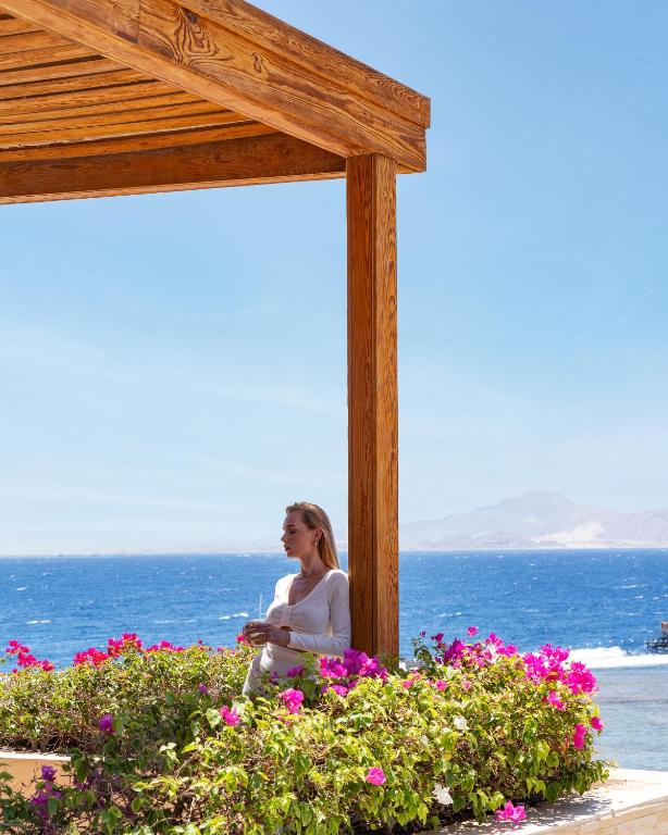 Sieviete, kas atpūšas pie ziediem, Cleopatra Luxury Resort, piekrastē