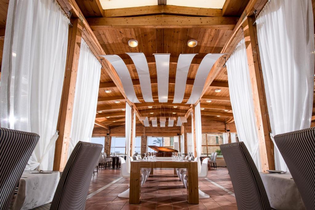 Bella Beach Hotel restorāns ar koka interjeru un gaisīgām aizkariem