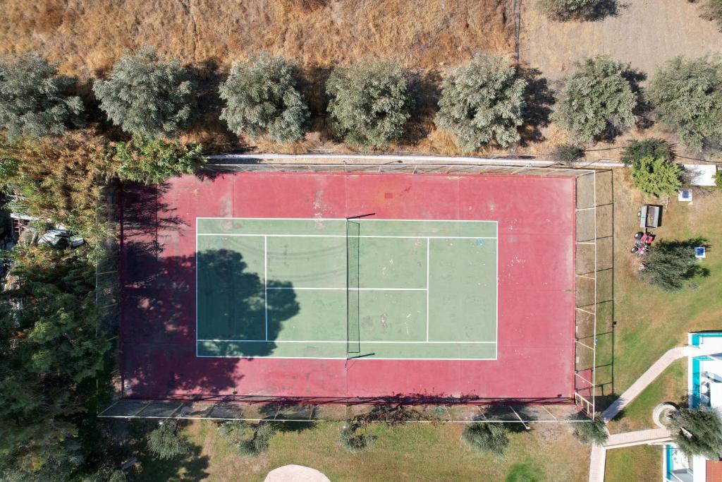 Tenisa korts pie Lydia Maris Resort & Spa, zaļš un sarkans, apzaļumots.