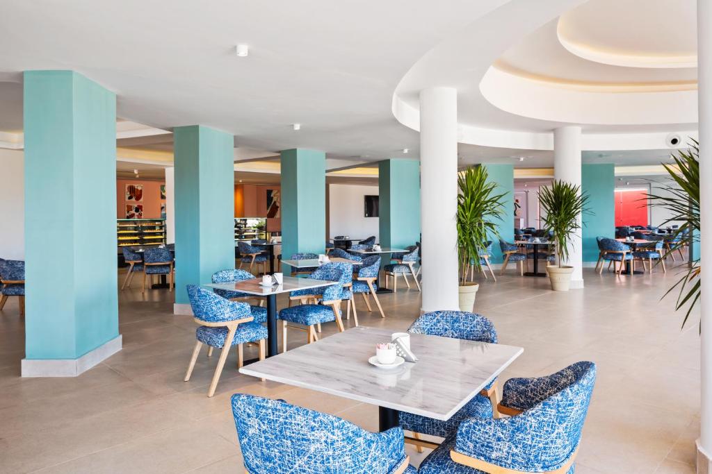 Mūsdienīgs restorāns ar ziliem krēsliem pie Pickalbatros Laguna Club Resort