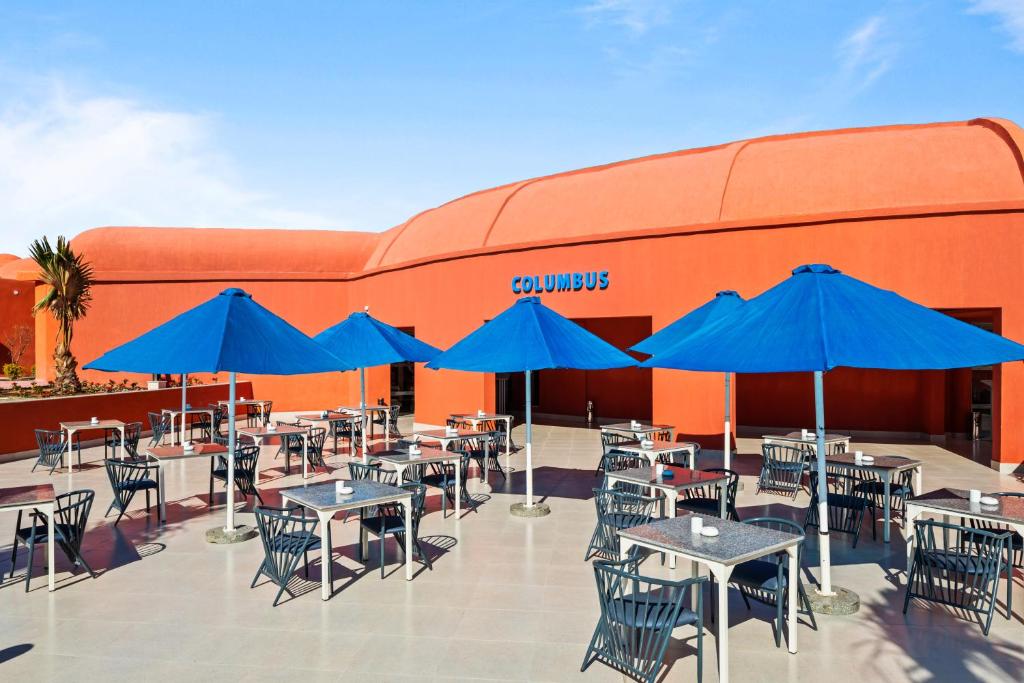 Pavērsiet acis uz Columbus restorānu Pickalbatros Laguna Club Resort ar ziliem saules aizsargiem.