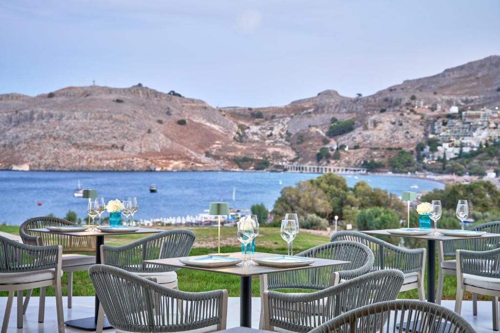 Lindos Grand Resort & Spa restorāns ar skatu uz jūru un kalniem.