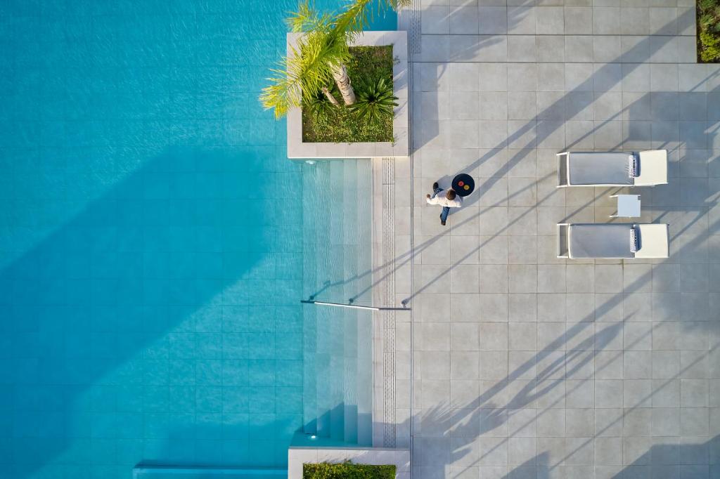 Lindos Grand Resort & Spa baseins ar viesi un sauļošanās krēsliem