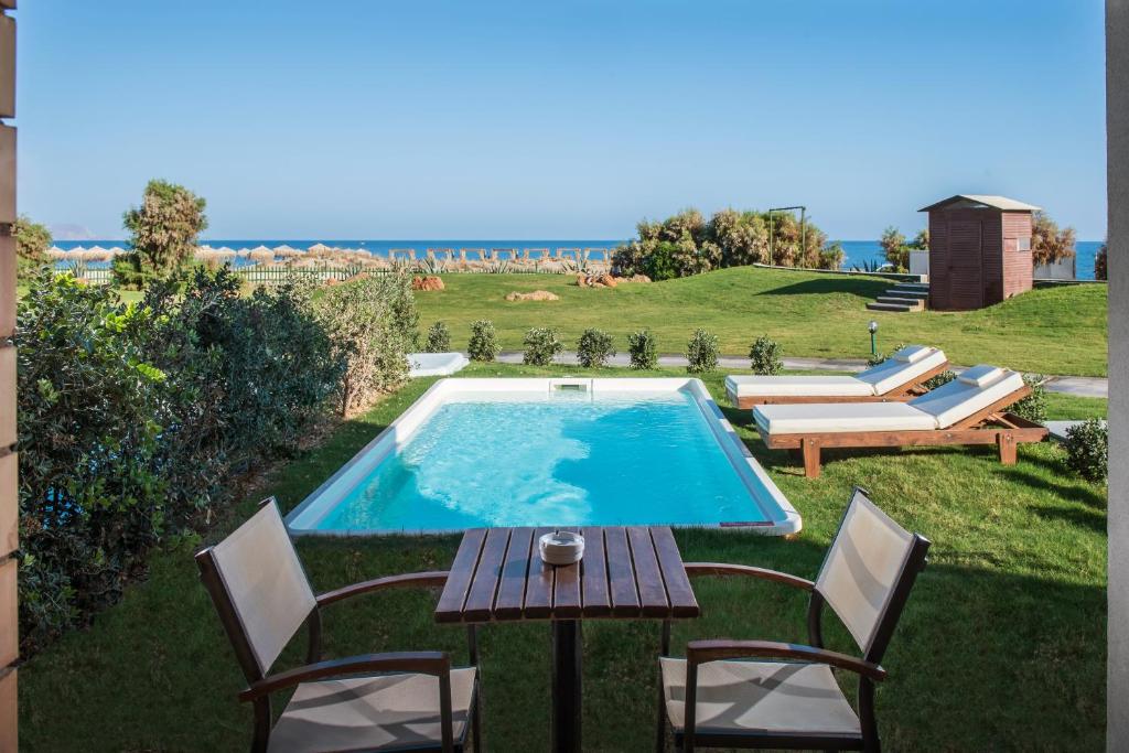 Bella Beach Hotel privātais baseins ar skatu uz jūru un sauļošanās krēsliem.