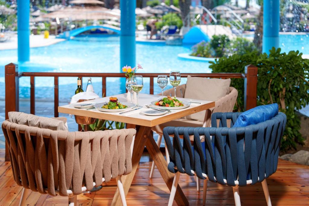 Romantiska pusdienu galda iestatījums pie Atrium Palace Thalasso Spa Resort And Villas baseina.