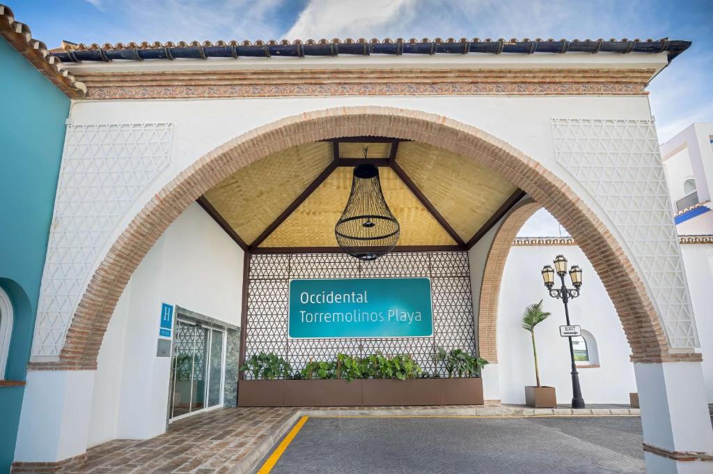 Galvenā ieeja Occidental Torremolinos Playa viesnīcā ar modernu arhitektūru un dekoratīvām detaļām. Dārzs un apgaismojums pievieno eleganci šai viesnīcai.
